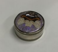 A circular silver box attractively decorated with