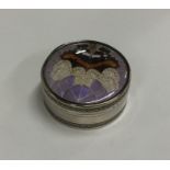 A circular silver box attractively decorated with