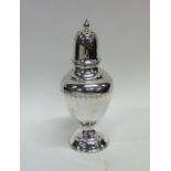 An Edwardian vase shaped silver caster decorated w