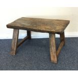 An Antique elm foot stool on tapering supports. Es