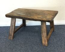 An Antique elm foot stool on tapering supports. Es