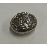 An oval silver cast pill box decorated with figure