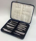 A good set of twelve silver tea knives with beaded