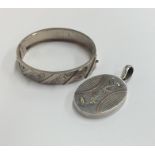 A silver oval locket with loop top together with a