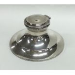 A silver tapering capstan inkwell with hinged top.