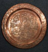 A large circular copper tray decorated with figure