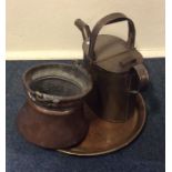 A brass watering can together with a copper basket