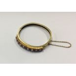 A heavy ruby and pearl half hoop hinged bangle wit