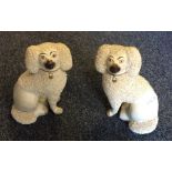 A pair of Staffordshire dogs in seated positions w
