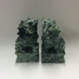 A pair of heavy green stone Dogs of Foo of typical