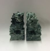 A pair of heavy green stone Dogs of Foo of typical