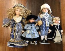 Four dressed porcelain headed dolls in blue outfit