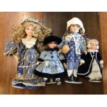 Four dressed porcelain headed dolls in blue outfit