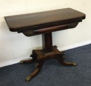 A Regency hinged top card table on four spreading