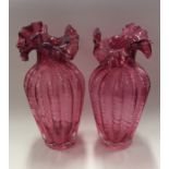 A pair of red cranberry glass vases with wavy edge