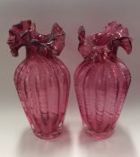 A pair of red cranberry glass vases with wavy edge