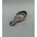 A modern cast silver caddy spoon with fluted bowl.