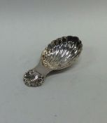 A modern cast silver caddy spoon with fluted bowl.