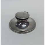 A small capstan shaped silver inkwell with hinged