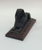 A bronzed figure of a sphinx on mahogany pedestal
