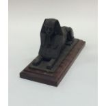 A bronzed figure of a sphinx on mahogany pedestal