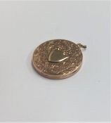 A circular 9 carat locket with shield front. Appro