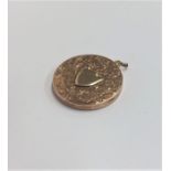 A circular 9 carat locket with shield front. Appro