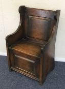 A small oak hinged top settle. Est. £20 - £30.