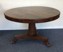 A circular rosewood loo table on tapering base. Es