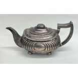 A Georgian silver half fluted teapot on four ball