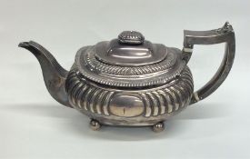 A Georgian silver half fluted teapot on four ball