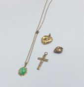 A small gold cross together with a locket, pendant