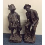A pair of tall brass mounted figures on square bas