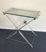 A rectangular retro glass top table on cross stret