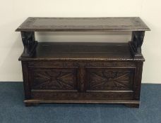 An oak carved and hinged top settle. Est. £60 - £8