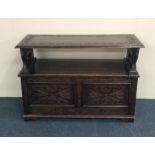 An oak carved and hinged top settle. Est. £60 - £8