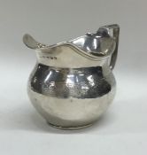 A Georgian silver squat cream jug with floral deco
