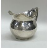 A Georgian silver squat cream jug with floral deco