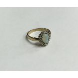 An opal and diamond cluster ring set in gold. Appr