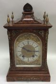 A burr walnut cased mantle clock with brass scroll