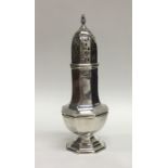 A small hexagonal silver caster on stepped base. A