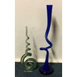 A tall blue glass spiral vase on flat base togethe