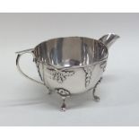 An unusual silver cream jug attractively decorated
