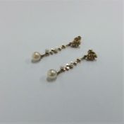 A pair of pearl mounted modernistic earrings in go