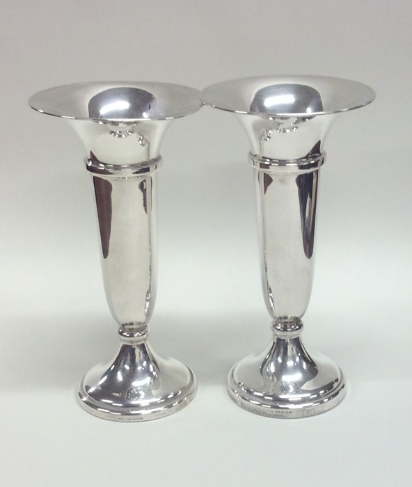 A pair of heavy plain tapering silver spill vases.