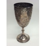 A Georgian style embossed silver trophy cup decora