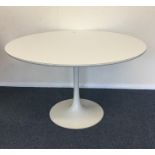 A circular retro kitchen table on spreading base.