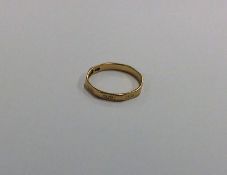 An 18 carat wedding band with Greek key pattern. A