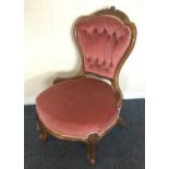 A small Victorian nursing chair on cabriole legs.