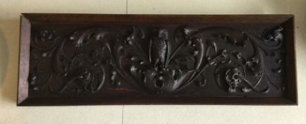 A carved oak panel decorated with an owl in relief